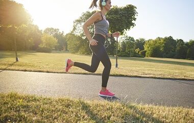 Side view of young woman running and listening to music side-view-of-young-woman-running-and-listening