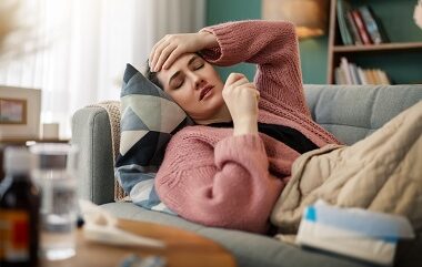 Young Woman at Home Feeling Unwell on Couch woman-with-headache-lies-on-couch-indoors.jpg